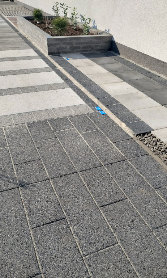 Nawierzchnie z kostki brukowej i betonowe kwietniki w ogródku wystawowym Betard