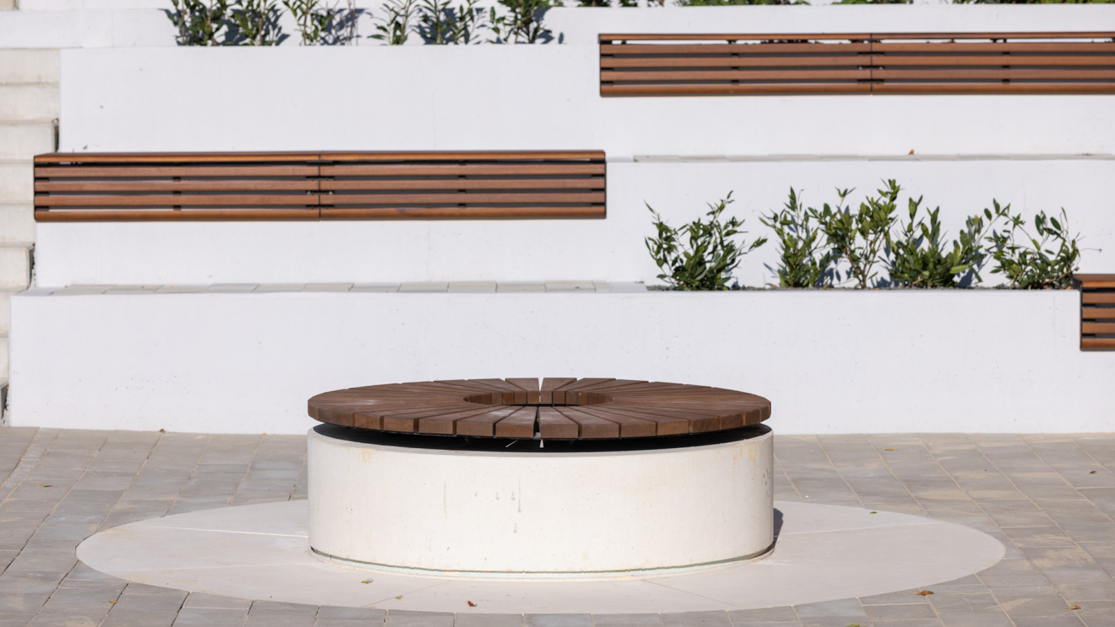 Okrągłe siedzisko oraz inne elementy betonowej zabudowy na osiedlu mieszkaniowym