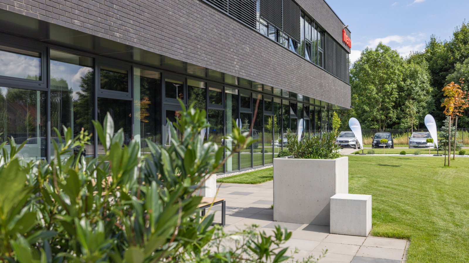 Betonowe siedziska i donice Cubo przed budynkiem biurowym