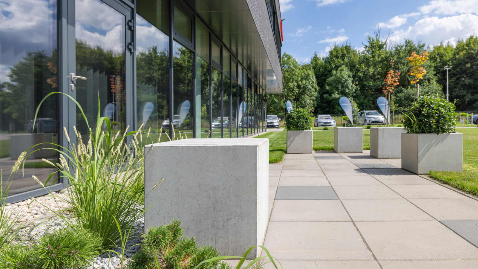 Betonowe siedziska i donice Cubo przed budynkiem biurowym