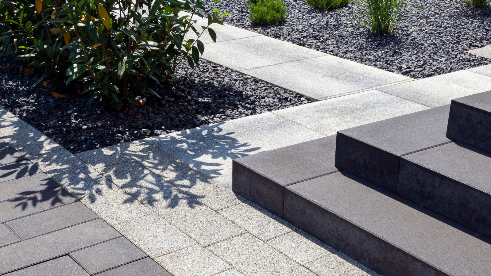 Schody z betonowych Stopni Scalino otoczone nawierzchnią z kostek Pianola i płyt Quattro