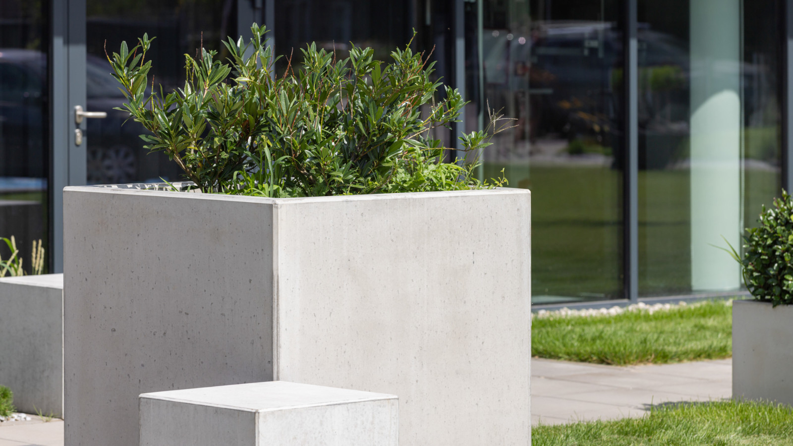 Betonowe siedziska i donice Cubo przed budynkiem biurowym