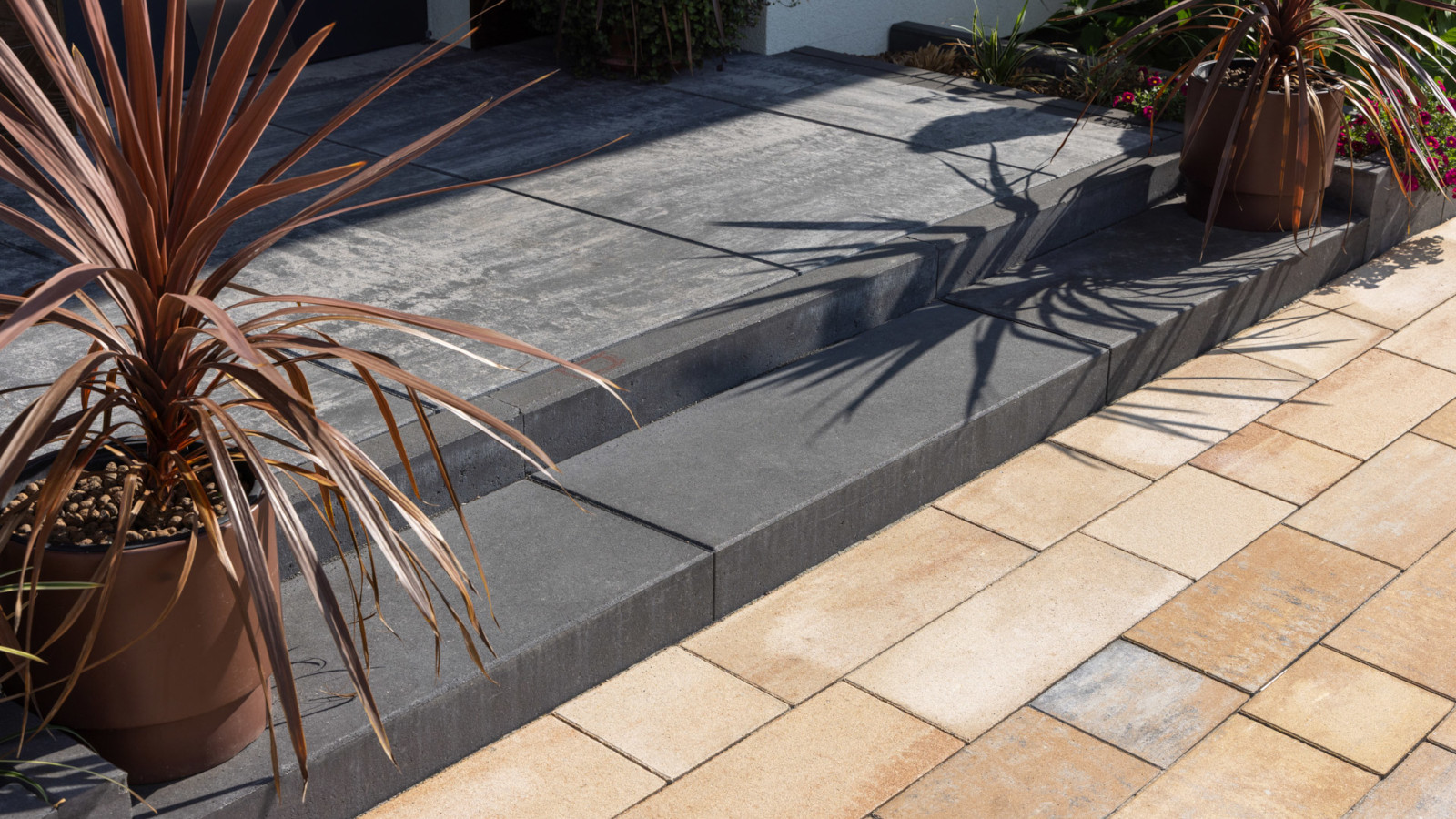 Wejście do domu wykonane ze stopni schodowych Scalino, obrzeży betonowych, kostek Pianola i płyt Quattro