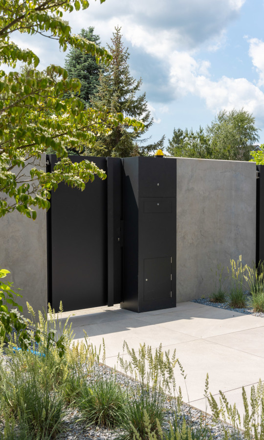 Wejście na posesję złożone z bramy i ogrodzenia ze ścian oporowych typu L